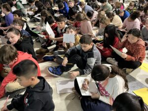 Students at Harrington Elementary School create drawings during an assembly with artist Bren Bataclan on Monday, March 16, 2026.