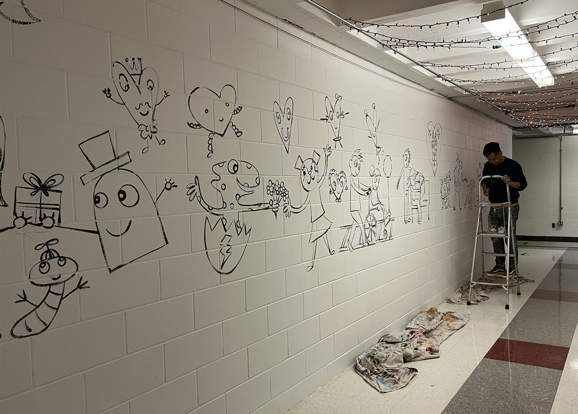 IMG_1919 Artist Bren Bataclan works on the mural in the hallway at Harrington Elementary School.