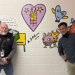 Harrington Elementary School Principal Rob Asselin, left, poses with artist Bren Bataclan in front of the freshly completed hallway mural on Friday, March 20, 2026.