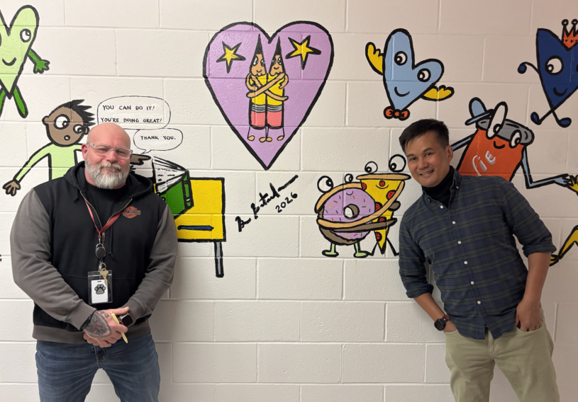 Harrington Elementary School Principal Rob Asselin, left, poses with artist Bren Bataclan in front of the freshly completed hallway mural on Friday, March 20, 2026.