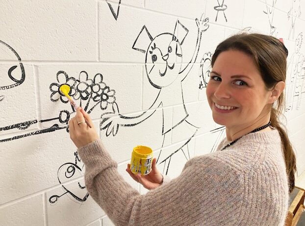 IMG_5589 Staff members at Harrington Elementary School add their personal touches to the hallway mural.