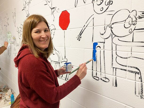 IMG_5590 Staff members at Harrington Elementary School add their personal touches to the hallway mural.