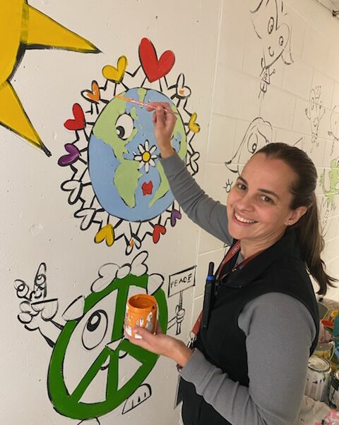 IMG_5592 Staff members at Harrington Elementary School add their personal touches to the hallway mural.