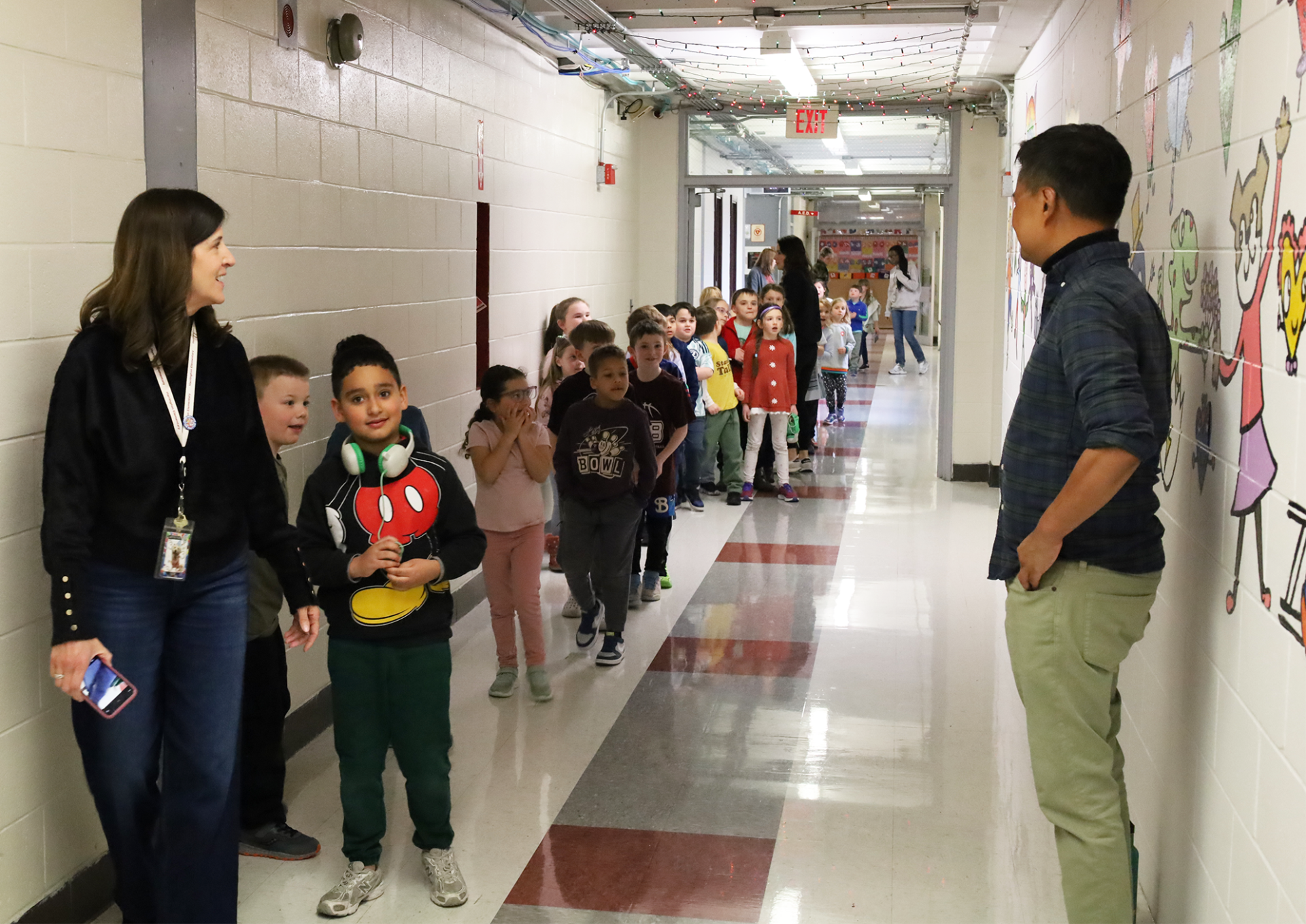 IMG_9379 Harrington Elementary School students do a walk-through of the hallway during the unveiling of Bren Bataclan's mural on Friday, March 20, 2026.