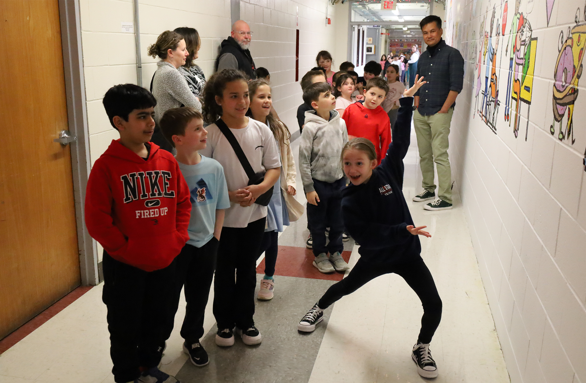 IMG_9397 Harrington Elementary School students do a walk-through of the hallway during the unveiling of Bren Bataclan's mural on Friday, March 20, 2026.