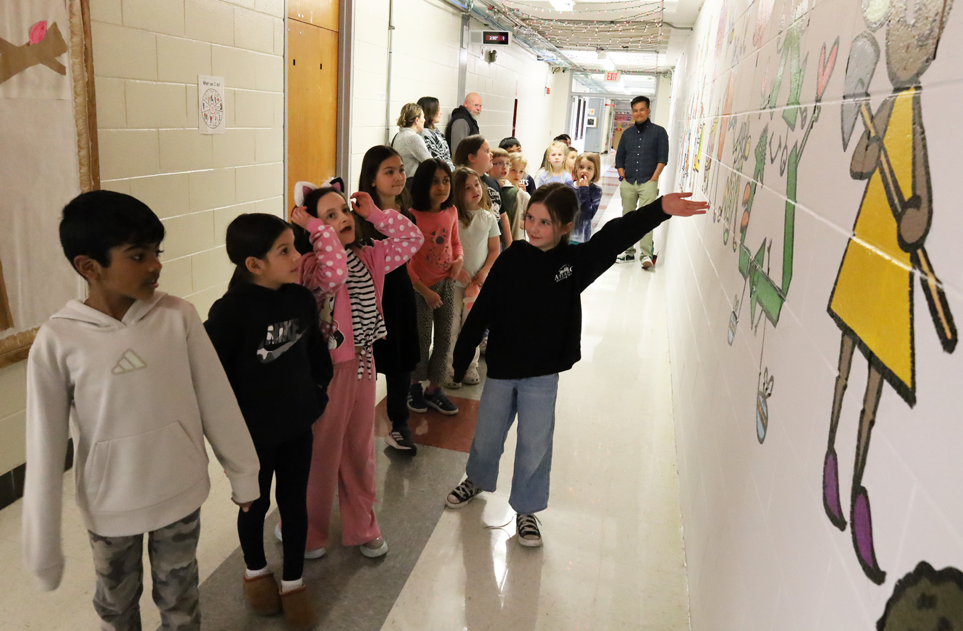 IMG_9404 Harrington Elementary School students do a walk-through of the hallway during the unveiling of Bren Bataclan's mural on Friday, March 20, 2026.
